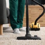 Dry,Cleaner's,Employee,Hoovering,Carpet,With,Vacuum,Cleaner,Indoors,,Closeup