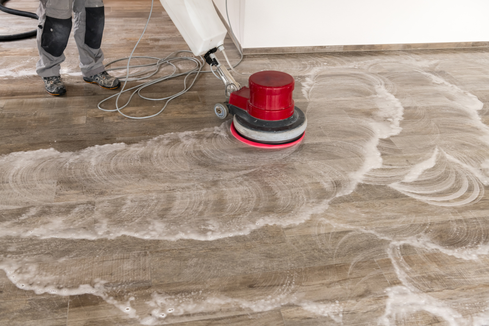 A man tile cleaning with a machine