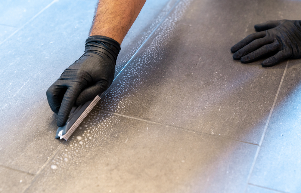 A close up of a professional doing grout cleaning