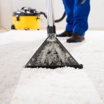 Close-up of a janitor carpet cleaning with vacuum cleaner
