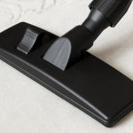 Cleaning white carpet with a vacuum cleaner and black universal vacuum