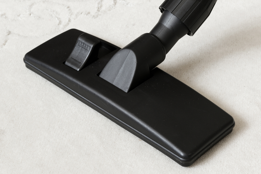 Cleaning white carpet with a vacuum cleaner and black universal vacuum